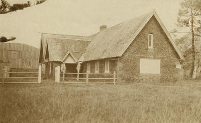 Photograph of Mission house with New Zealand Flying School hangar in background