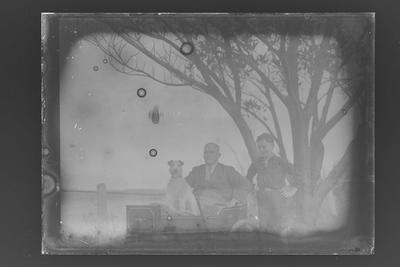 [Black and white glass plate negative of man and dog]
